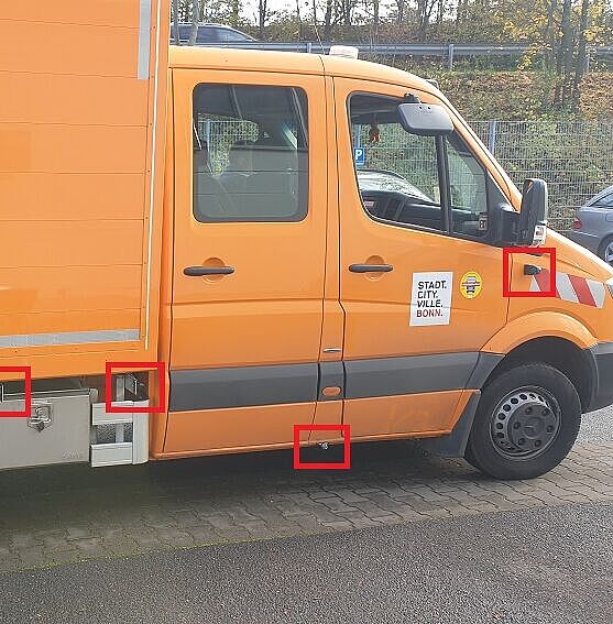 Die roten Rahmen weisen auf die Sensoren des Abbiegeassistenten an einem orangefarbenden Lieferwagen  hin.