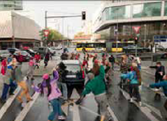 Stark von Passanten, Fahrradfahrenden und Autos frequentierte Straße in Berlin