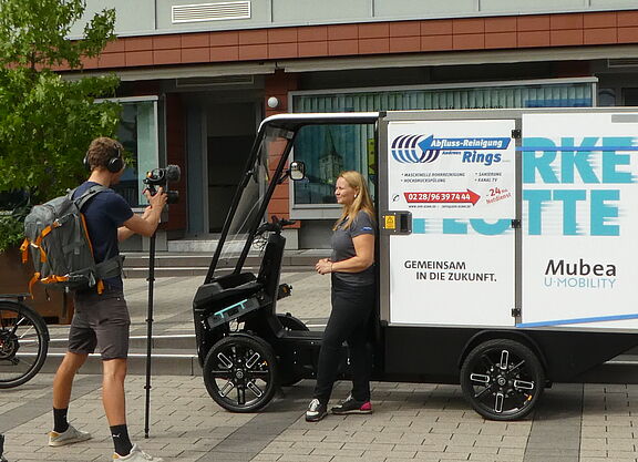 großes Lastenrad mit danebenstehender Fahrerin