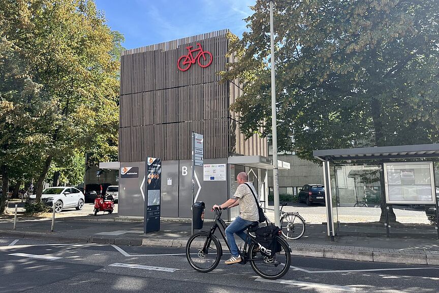 Fahrradparkhaus mit Fahrradfahrer am Eingang