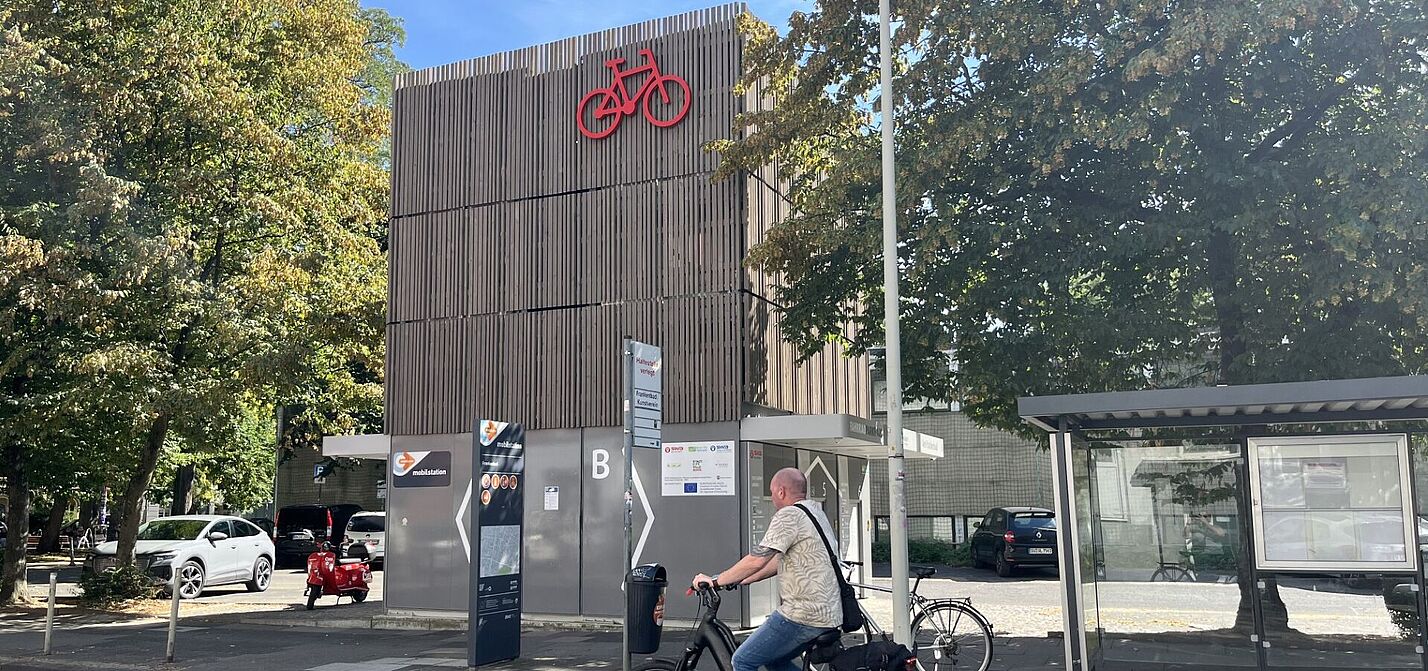 Fahrradparkhaus mit Fahrradfahrer am Eingang